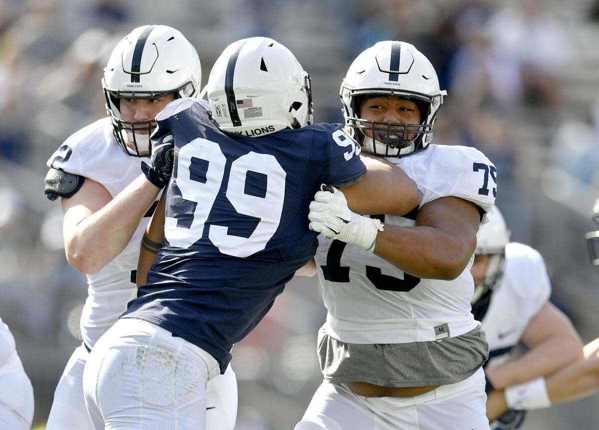 Penn State offensive linemen Bryce Effner and Des Holmes try to stop defensive end Yetur Gross-Matos during the Blue-White game on Saturday, April 13, 2019.