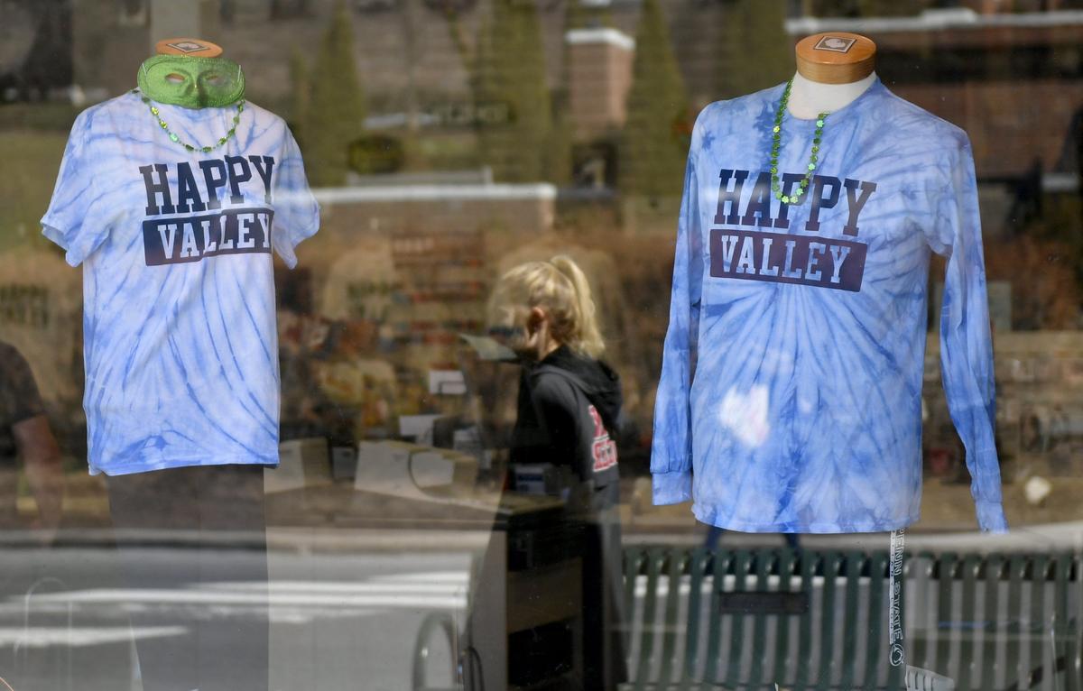 The reflections of students appear in window displays Tuesday, March 12, 2019, at The Student Book Store on College Avenue. The store carries apparel featuring the words “Happy Valley.”