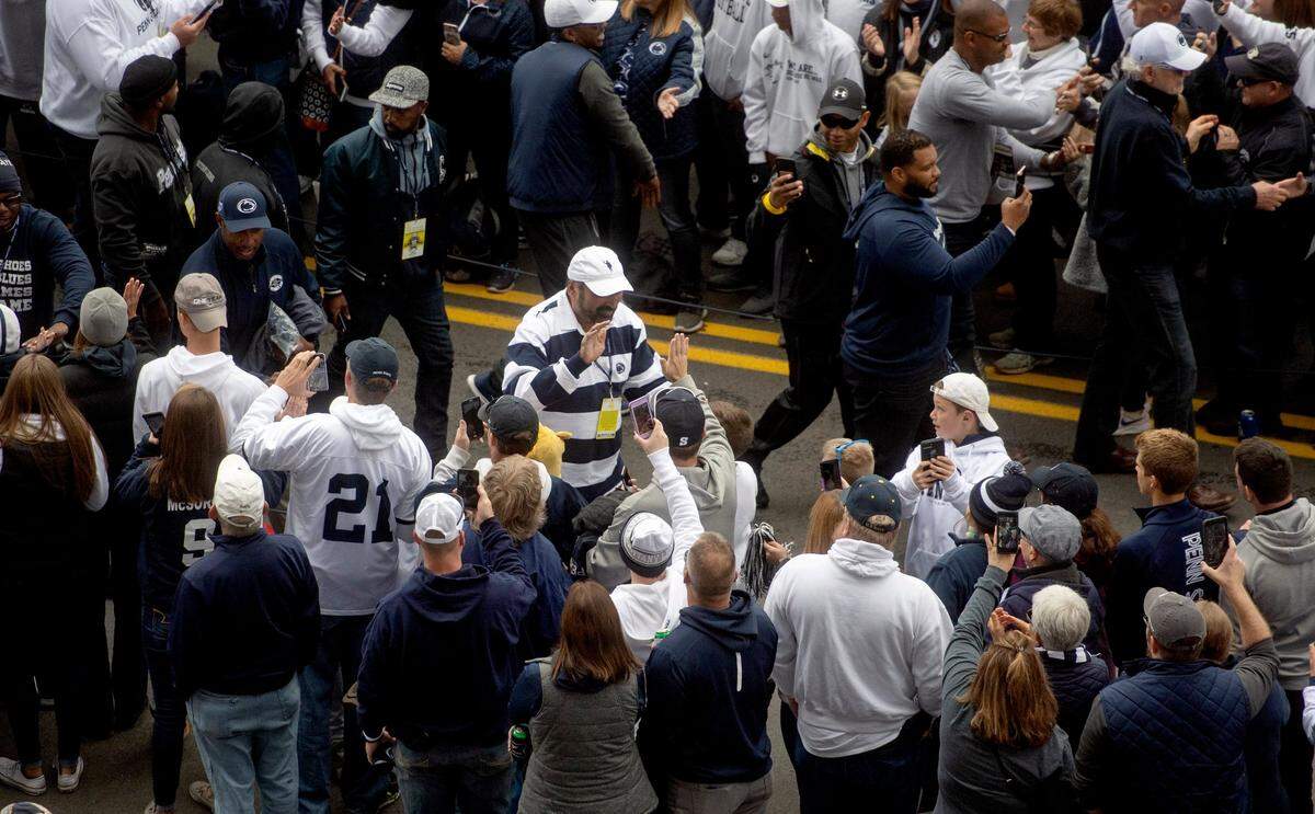 Harris high-fives fans as he arrives with the Penn State football team for the homecoming game against Michigan State in 2018.