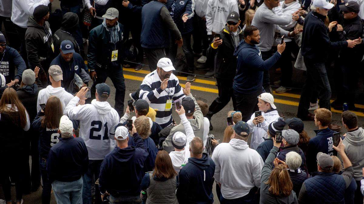 Former Penn State and Steelers player Franco Harris high-fives fans as he arrives with the Penn State football team for the homecoming game against Michigan State on Saturday, Oct. 13, 2018.