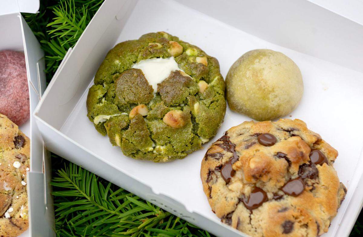 Treats from Pouf Patisserie including a matcha macadamia cookie, a pistachio bomb and a chocolate chip walnut cookie.
