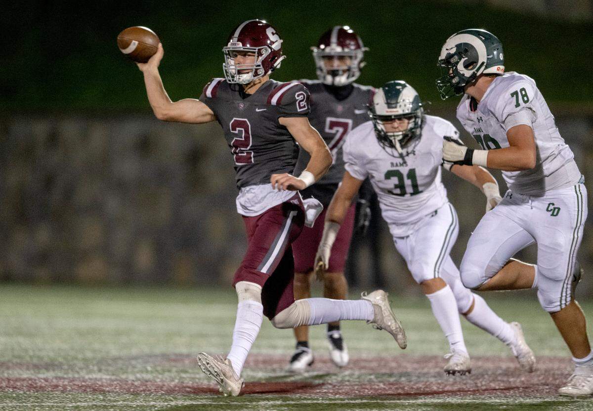 State College’s Finn Furmanek makes a running pass while being pressured by Central Dauphin defenders during the game on Friday, Sept. 23, 2022 at Memorial Field.