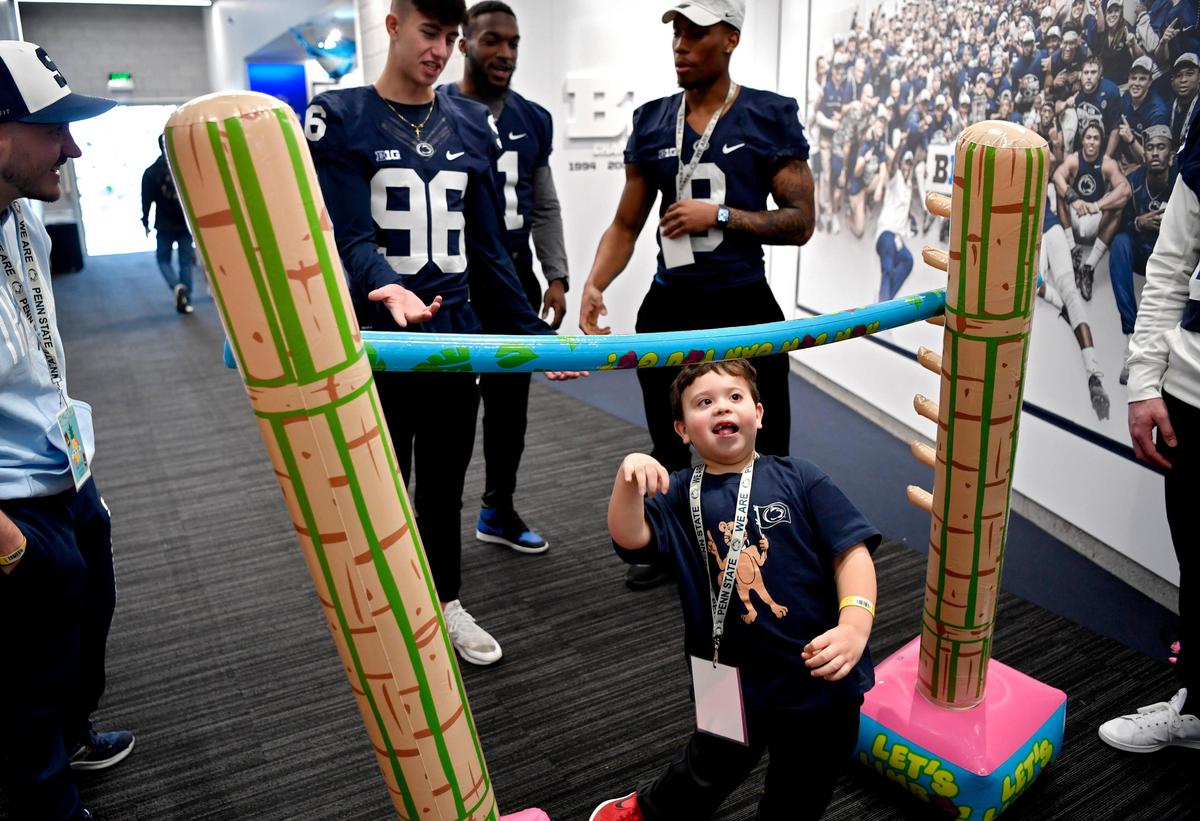 Leiland Smith, 5, does the limbo with a group of Penn State football players at the Lasch Building on Saturday, Feb. 22, 2020.