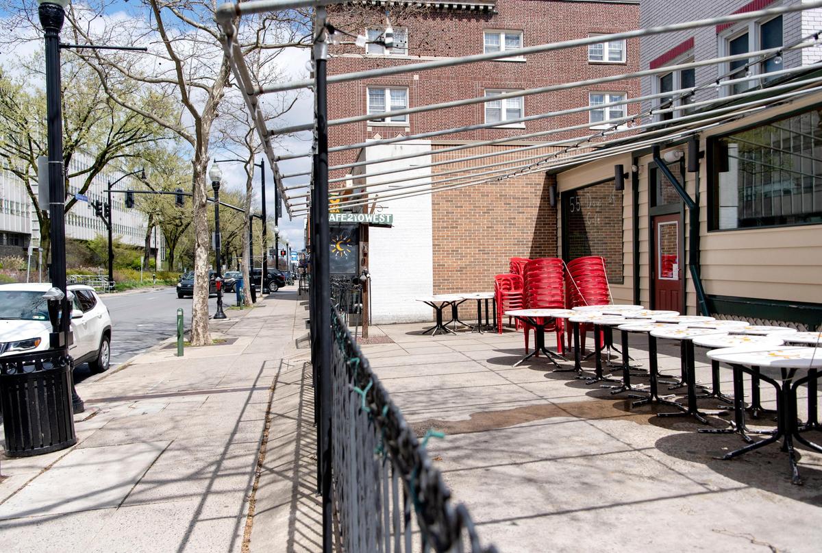 No one walks along College Avenue in front of Cafe 210 West where all the tables and chairs were stacked on Saturday, April 18, 2020.