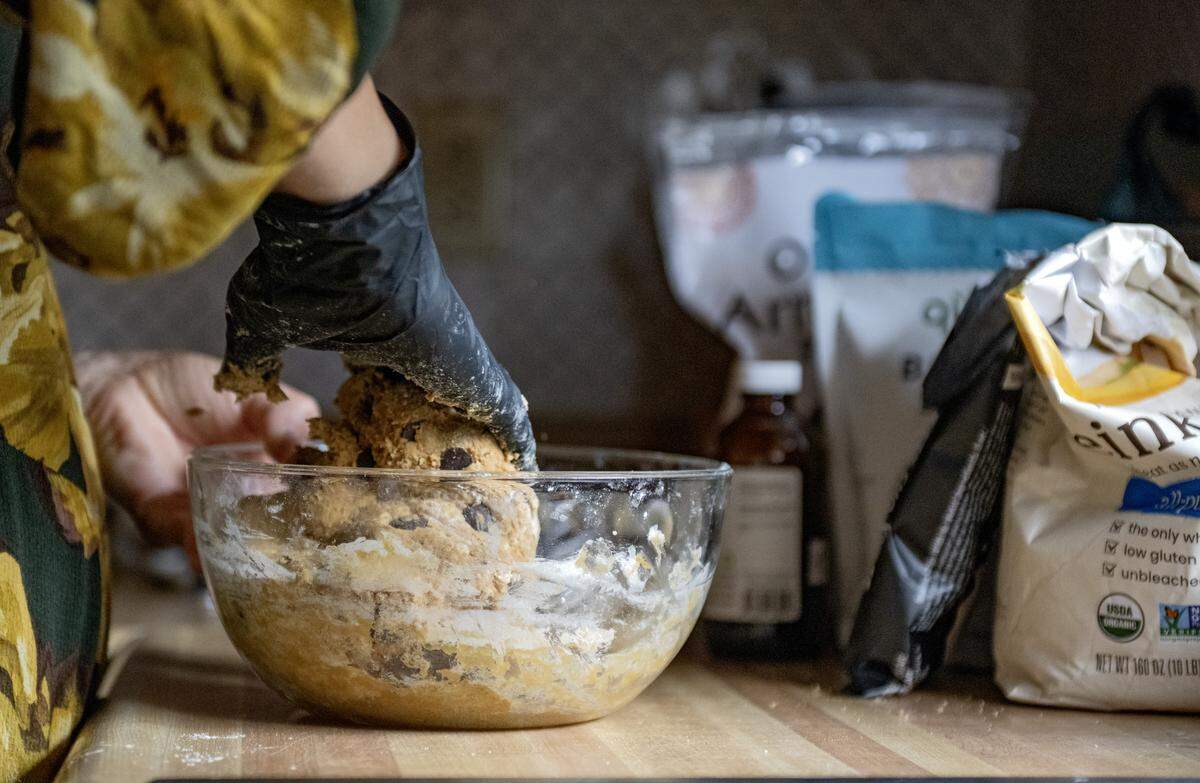 Alyssa Burns of Blackberry Cottage Bake Shoppe mixes a batch of chocolate chip cookies by hand on Friday, Nov. 14, 2025. The cookies are made with organic einkorn flour and no refined sugars.  