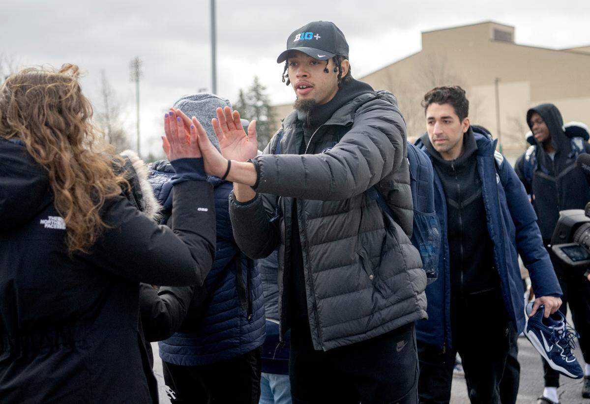 Penn State’s Seth Lundy high fives fans as he and the team leave for the NCAA tournament on Tuesday, March 14, 2023.