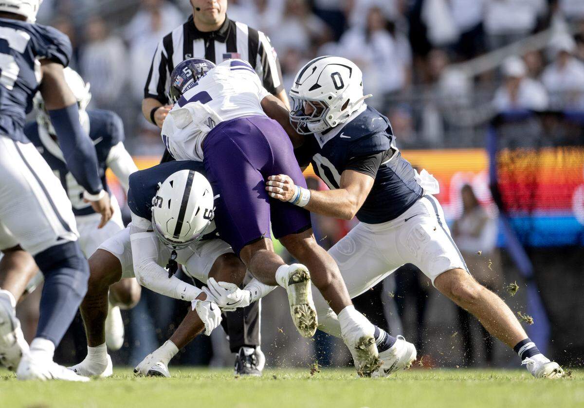Penn State safety Zakee Wheatley and linebacker Dominic DeLuca stop Northwesterns’ Caleb Komolafe during the game on Saturday, Oct. 11, 2025.