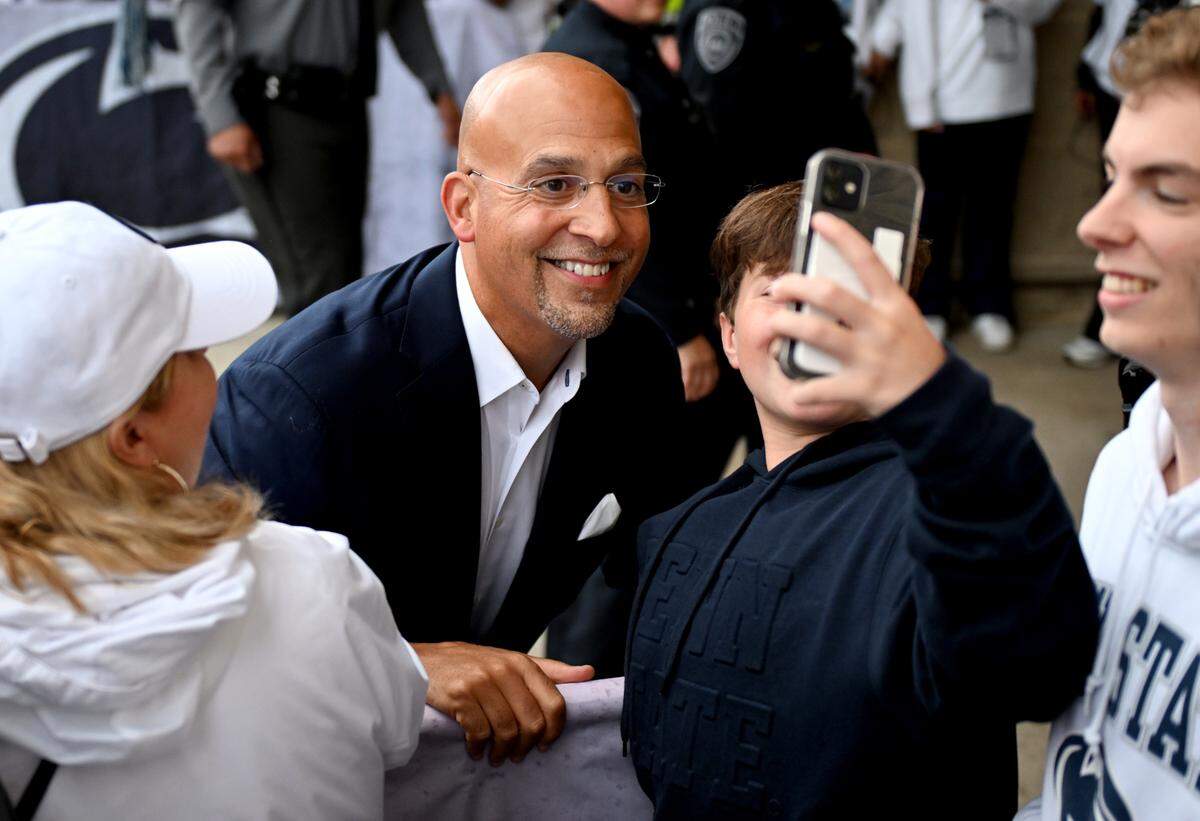 Penn State football coach James Franklin smiles for a selfie with a young fan as the team arrives at Beaver Stadium for the Homecoming game on Saturday, Sept. 28, 2024.