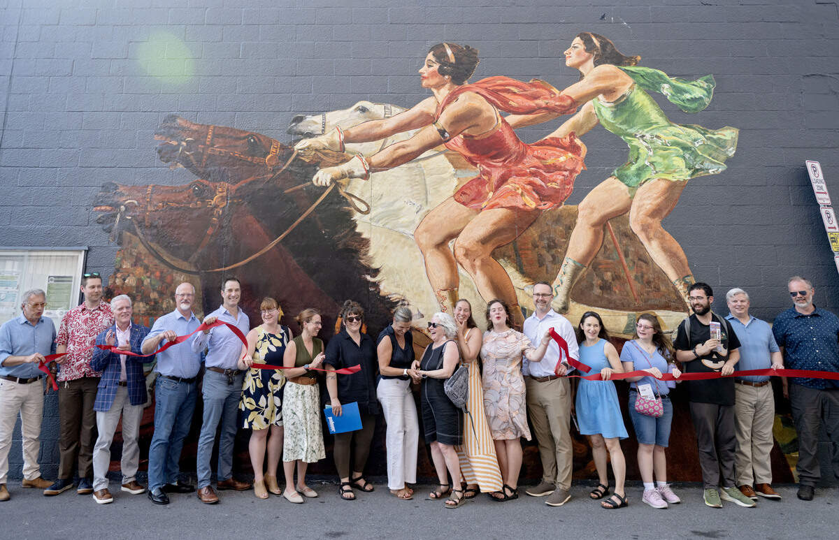 People who helped make the “Looking at US: Celebrating America’s 250th” installation possible around downtown State College celebrate in front of the “The Roman Standing Race” by Gifford Beal on Wednesday, July 1, 2026.”