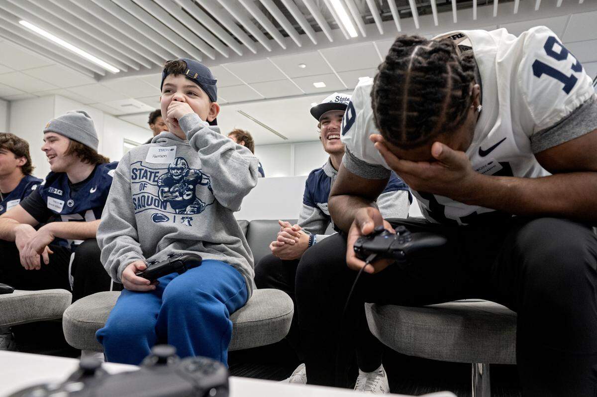 Harrison Fischman, 10, laughs as he scores against Penn State football player Yvan Kemajou in a video game on Saturday, Feb. 21, 2026 in the Lasch Building. 