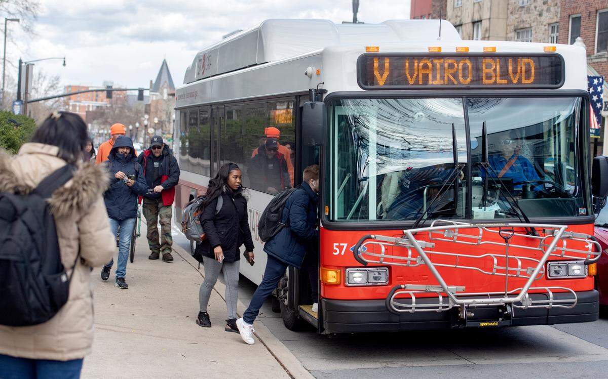 Bus riders board a CATA bus on College Avenue without masks on Tuesday.