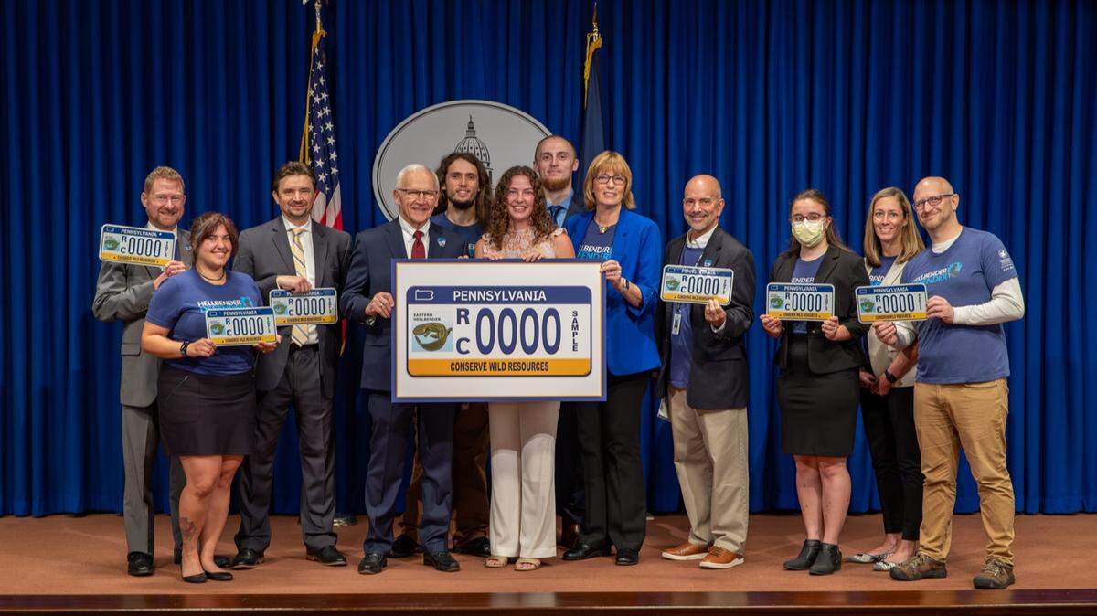 Attendees pose at a 2023 Harrisburg event celebrating a license plate featuring the state amphibian.