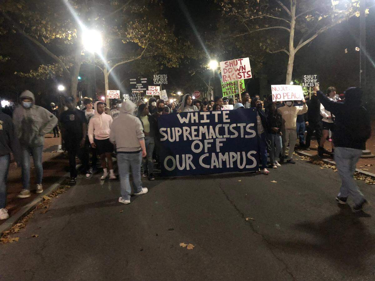 Protesters march on Pollock Road on Penn State’s University Park campus on Monday night after an event featuring the founder of the Proud Boys was canceled.