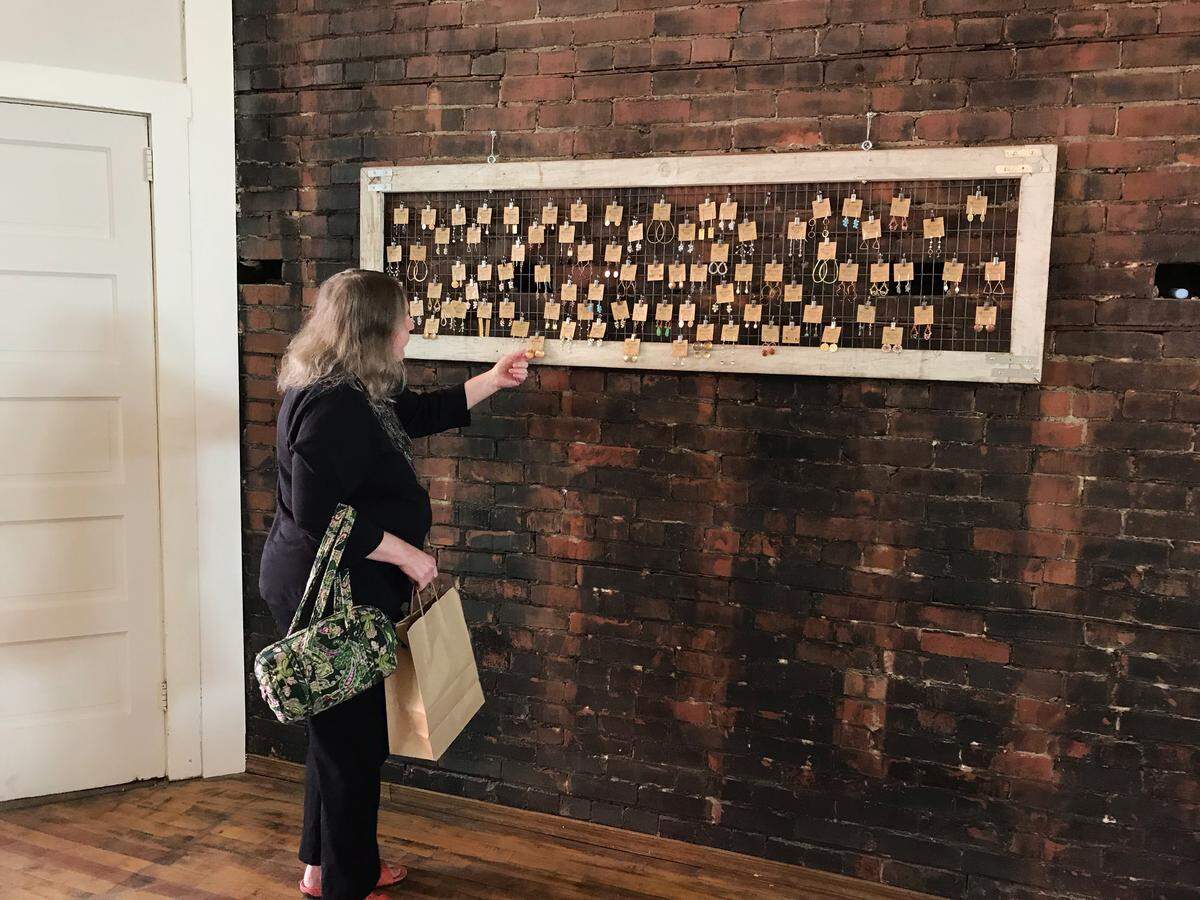 A customer looks at earrings from Staci Egan’s Contempo Jewelry line at Smith and Front, a new art studio and gallery in downtown Philipsburg.