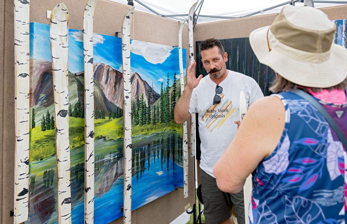 Bobby Vanek talks to visitors about his “ski-D” art at the People’s Choice Festival of Pennsylvania Arts & Crafts on Friday, July 12, 2024. Some of Vanek’s paintings use recycled skies as trees that can be moved on and off and placed in different locations.