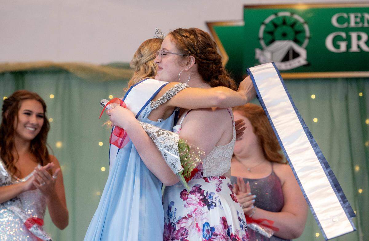 The 2021 Grange Fair Queen Mattee Stoicheff, left, hugs Ella Smith after she is named 2022 Centre County Grange Fair Queen during the coronation on Wednesday, Aug. 17, 2022.