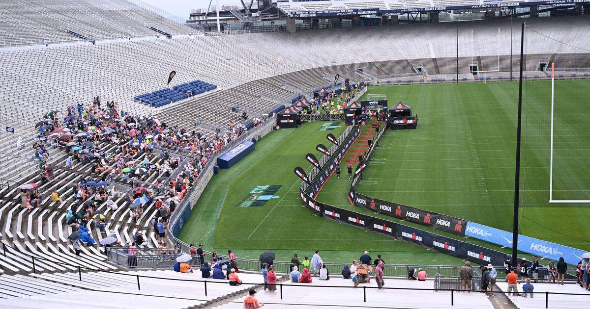 Families and friends of participants in the Ironman 70.3 Pennsylvania Happy Valley watch runners cross the finish line inside Beaver Stadium on Sunday, July 2, 2023.