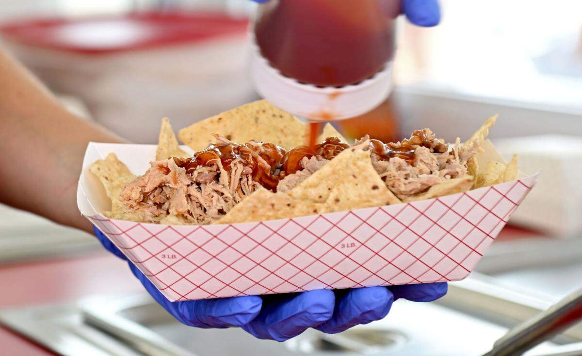 Pulled pork nachos are made at Scott’s Roasting at the Centre County Grange Fair on Friday, Aug. 16, 2024.