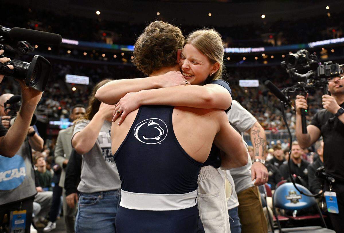 Penn State's Levi Haines hugs his wife after winning the 174-pound title at the NCAA wrestling championships on Saturday, March 21, 2026.