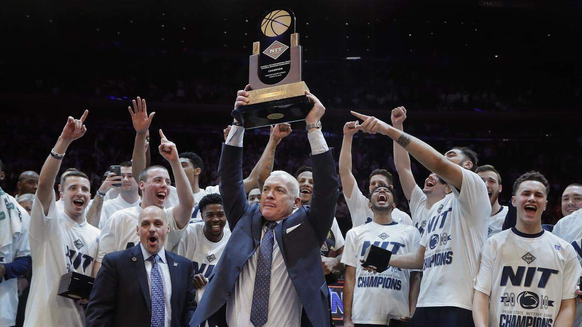 Penn State coach Pat Chambers holds up the NIT championship trophy after Penn State defeated Utah 82-66 in an NCAA college basketball game Thursday, March 29, 2018, in New York.