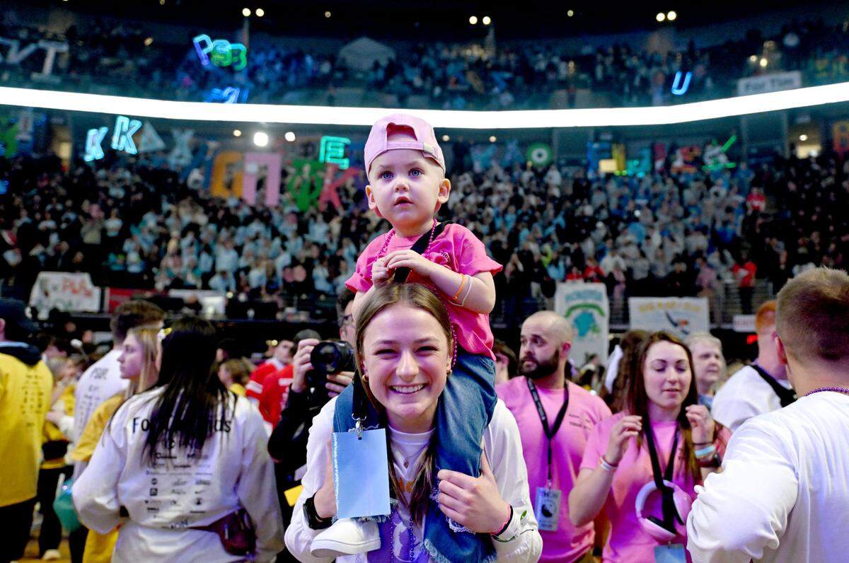 Blakely Kling, 2, takes in Penn State Thon from the shoulders of a dancer on Friday, Feb. 21, 2025.
