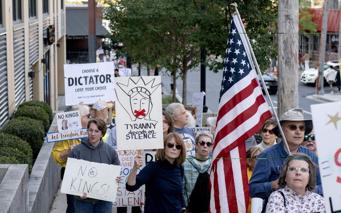 Protesters marched on the sidewalks along Garner Street as part of the No Kings anti-Trump rally on Saturday, Oct. 18, 2025. The march looped through downtown State College.  