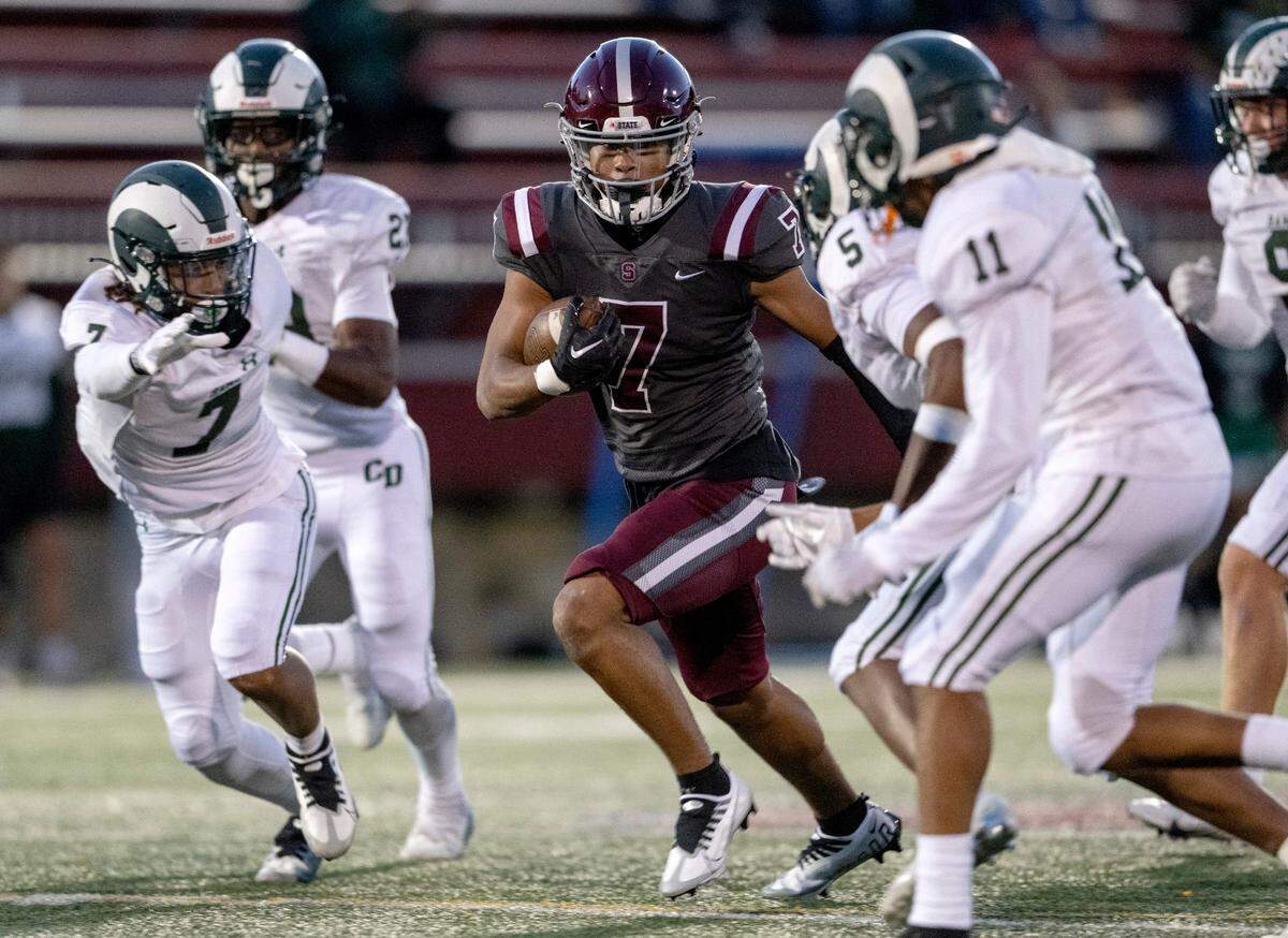State College’s D’antae Sheffey runs down he field with the ball from Central Dauphin defenders during the game on Friday, Sept. 23, 2022 at Memorial Field.