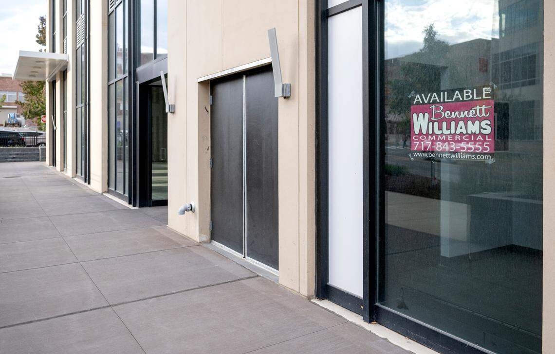 Signs for spaces for lease are in the windows of the empty storefronts at The Standard on the corner of West College Avenue and Atherton Street.
