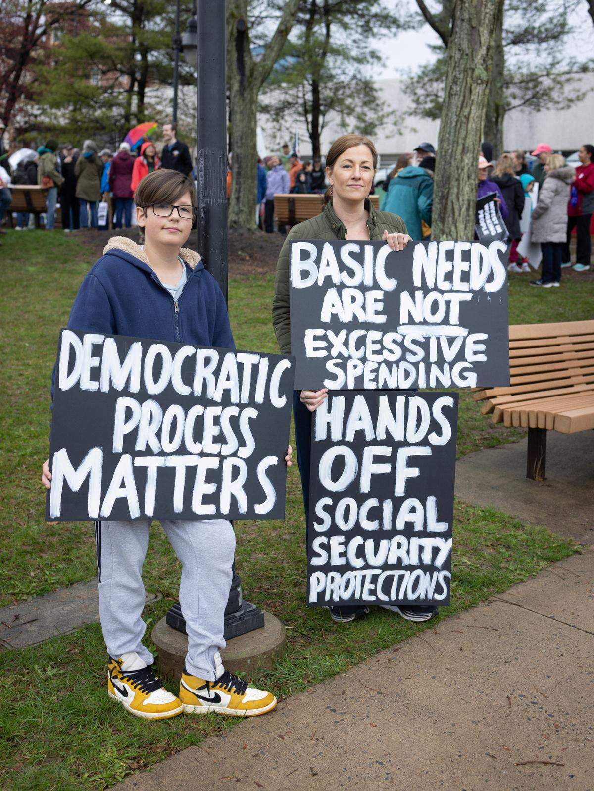 Josiah Shepski, left, and Rebecca Shepski hold signs Saturday while listening to speakers at the “Hands Off!” rally at State College’s Sidney Friedman Park, in opposition of President Donald Trump. The event was part of a nationwide effort that saw more than 1,000 similar rallies held across all 50 states.