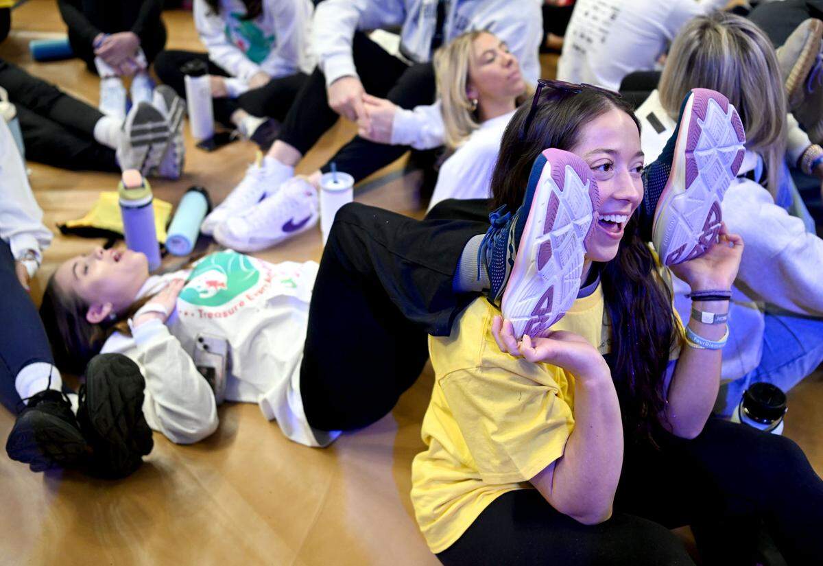 Sophia Griffin sings along with a performance as she holds up the feet of dancer Juliana Toohey before the start of the 46 hour Penn State IFC/Panhellenic Dance Marathon on Friday, Feb. 16, 2024 at the Bryce Jordan Center.