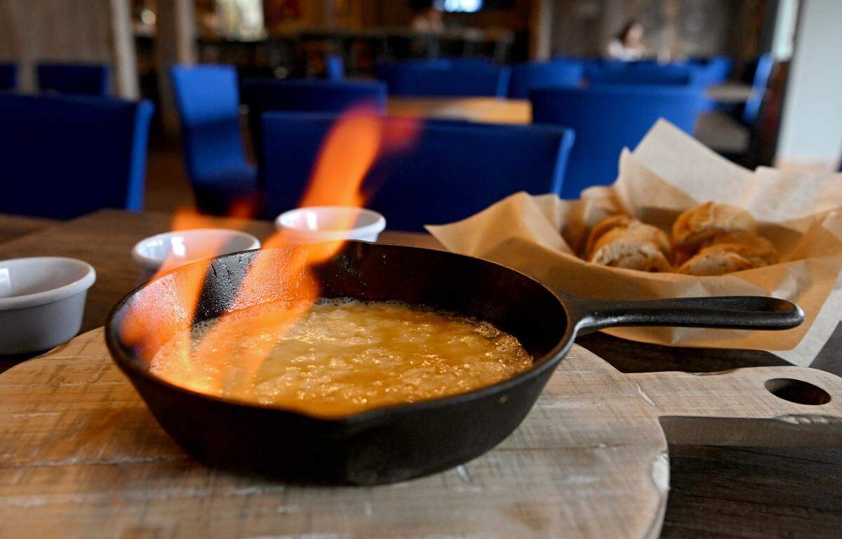 The flaming cheese skillet of pan fried Greek sheep’s milk cheese is flambeed tableside at Tussey Bär and Kitchen.