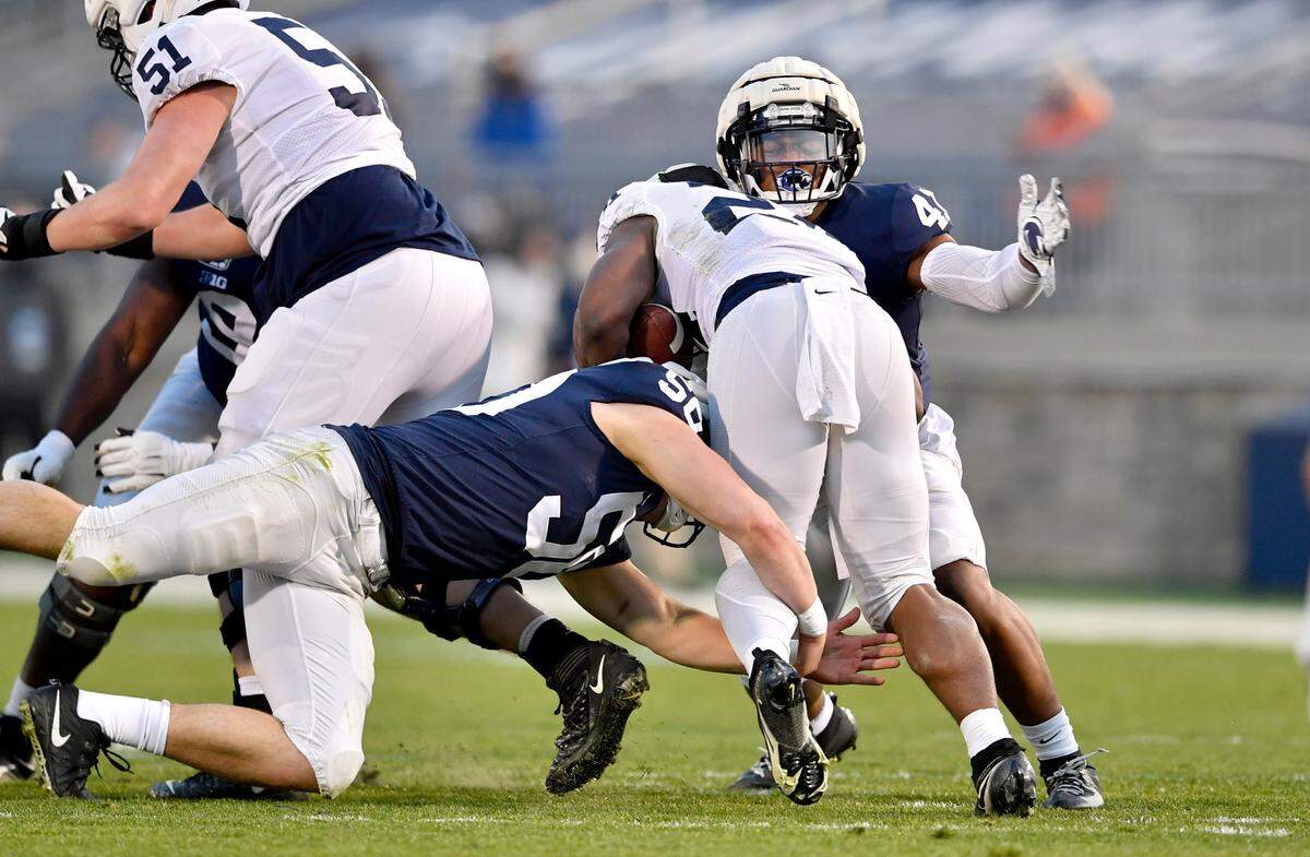 Linebackers Max Chizmar and Kobe King stop running back Keyvone Lee during Penn State football practice on Friday, April 23, 2021 at Beaver Stadium.