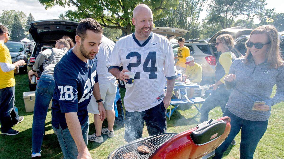 Penn State alum Don Montina grills up some burgers as he tailgates with fellow Penn State fans and Michigan fans outside of Michigan Stadium before the Penn State game in September 2016.
