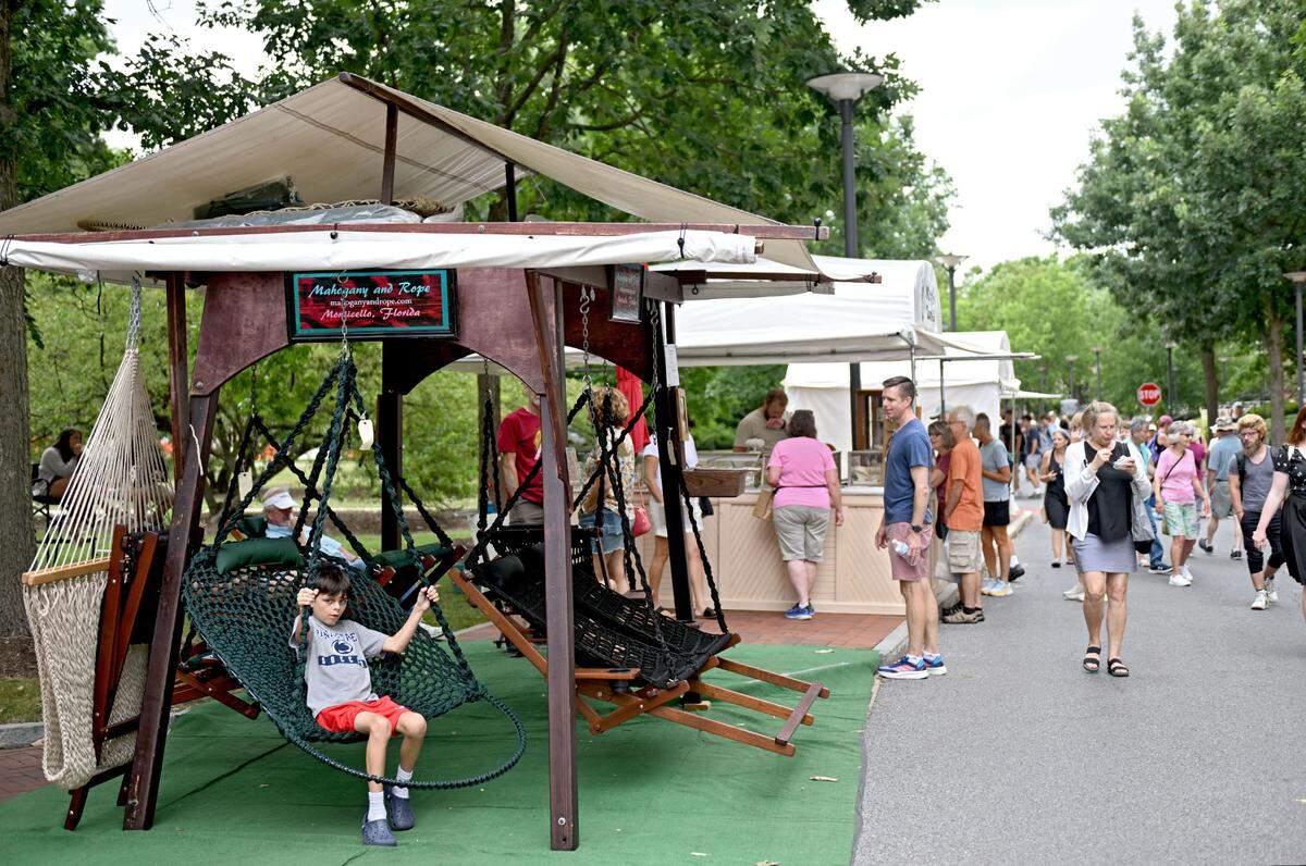 A youngster tries out one of the mahogany and rope swings by Victor Edwards at the Central Pennsylvania Festival of the Arts on Thursday, July 11, 2024.