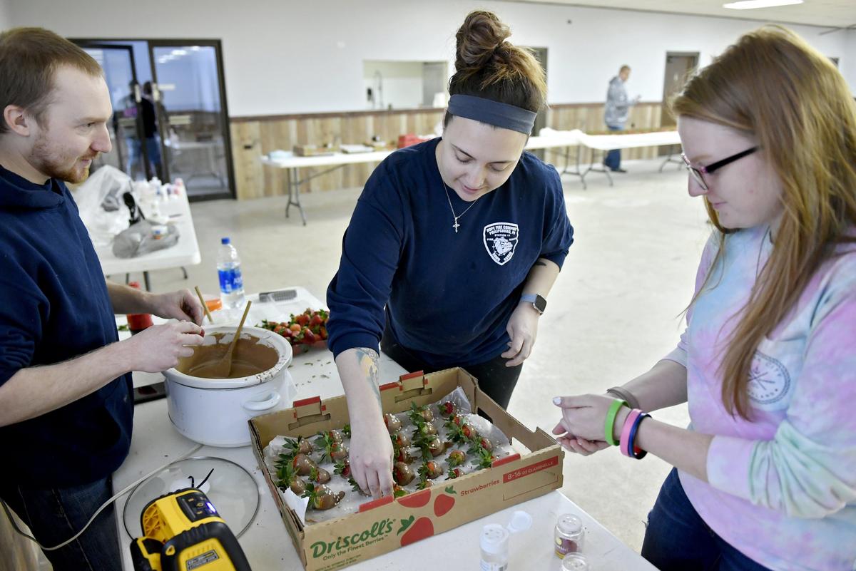 Matt Rebmann, Casey Cartwright and Maccee Rebmann make chocolate covered strawberries on Feb. 12 for the Hope Fire Company Valentine’s Day fundraiser.