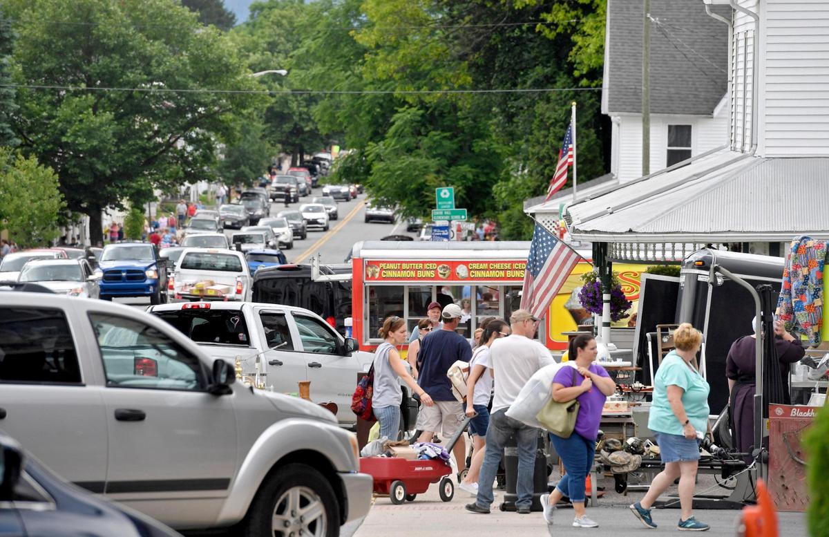 Lines grow at food stands as people walk along Pennsylvania Avenue in Centre Hall for the annual town-wide yard sale on Friday, June 26, 2020.