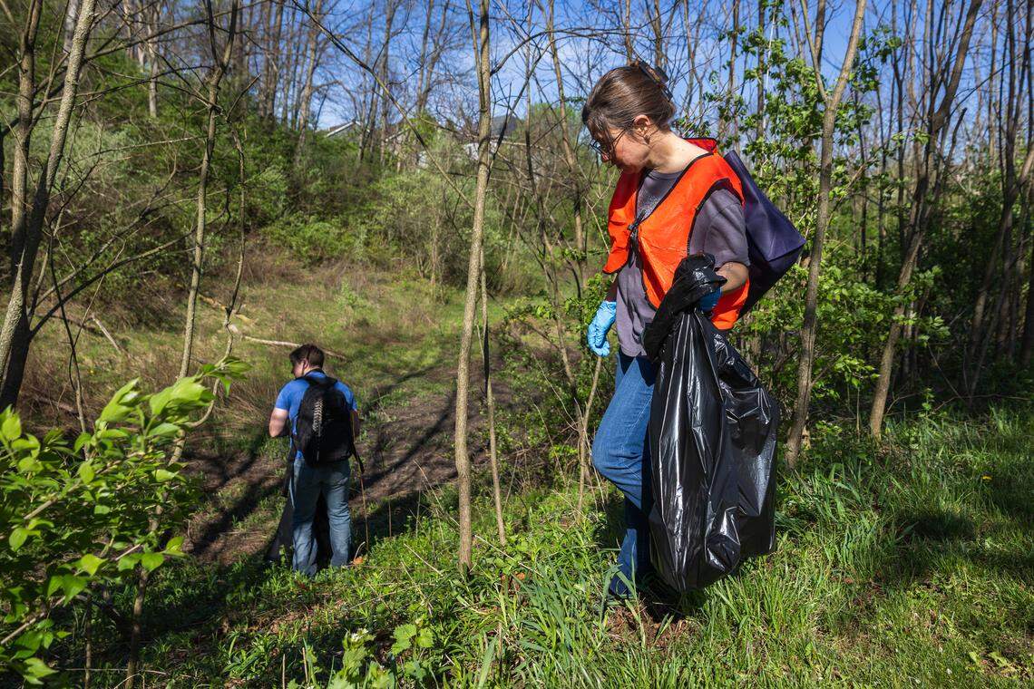 Volunteers AJ Legmier, right, and Trevor White, left, walk into a ditch to collect trash in Pine Grove Mills, Pa., on Saturday, April 18, 2026. The ClearWater Conservancy organized volunteers across Centre County to clean up public green spaces.