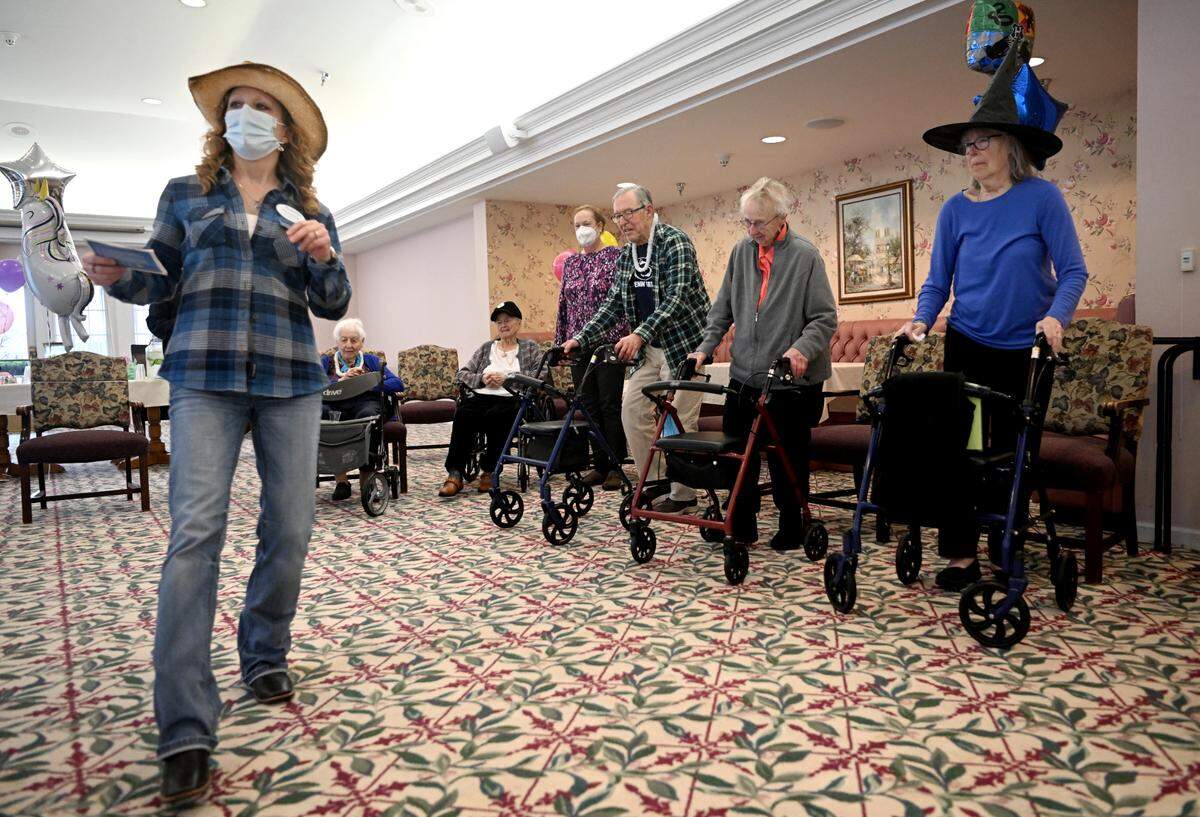 Residents of Juniper Village at Brookline senior living follow the the line dance moves of physical therapist Heather Walker Monday during their mini-Thon celebration. Residents danced for 46 minutes as they raised money for Penn State’s 46-hour dance marathon.