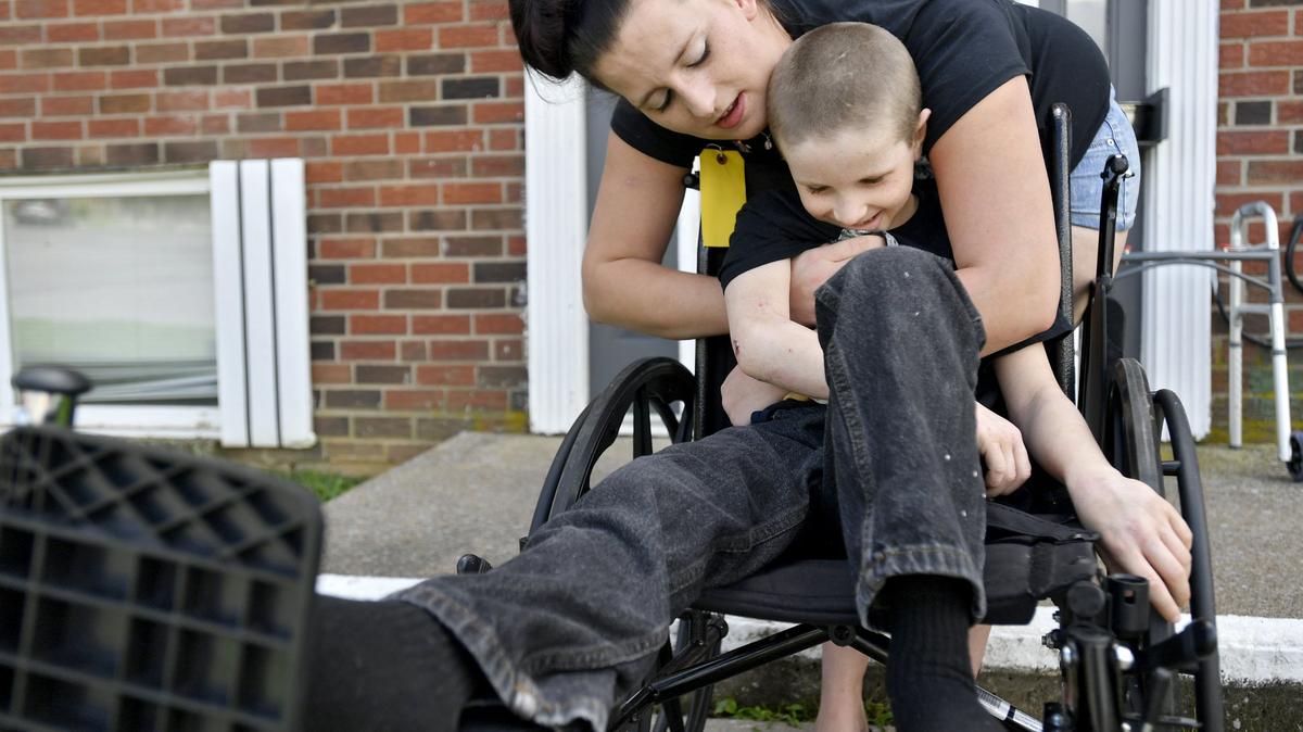 Evan Askins, 7, laughs as his mom Lisa Askins gives him a hug on Thursday. After being hit by a car on July 26, Evan will be in a wheelchair for several months to recover from surgery where a rod was put in to fix his femur.