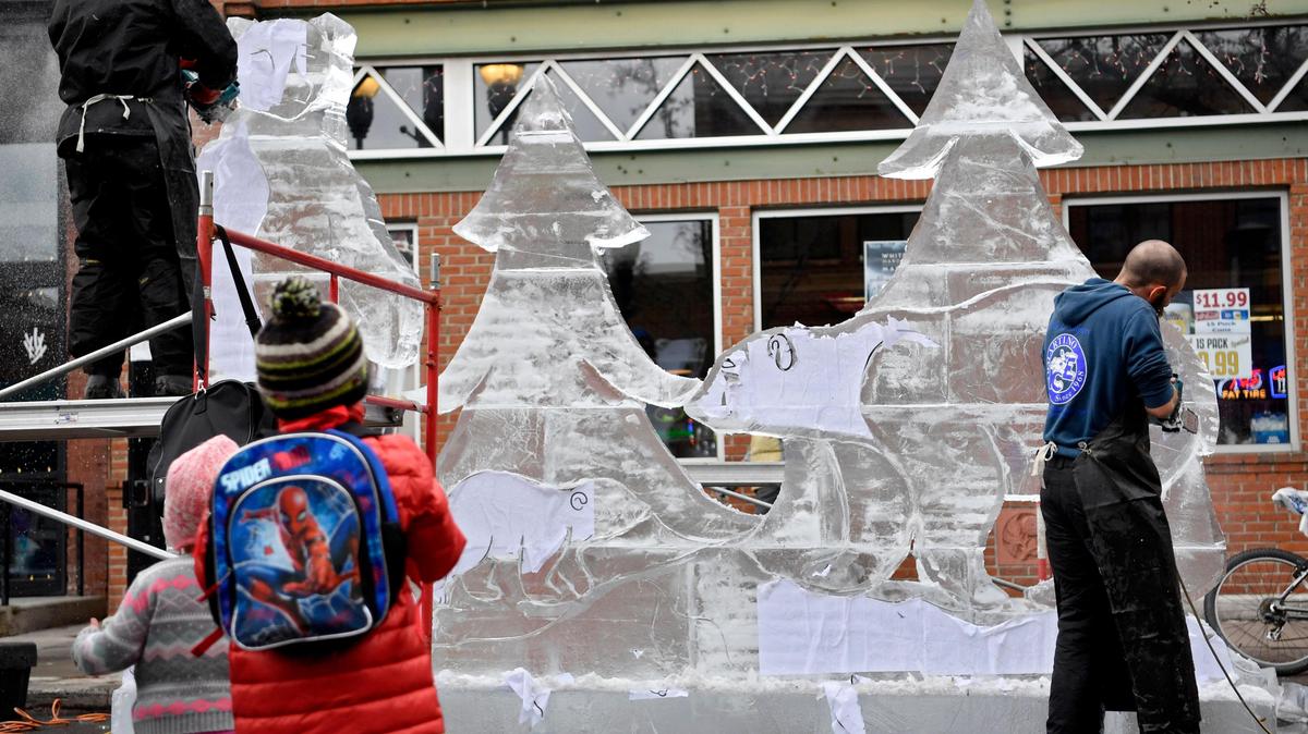 Youngsters watch the crew from Di Martino Ice carve the sculptures along Allen Street as part of First Night on Dec. 31, 2019.