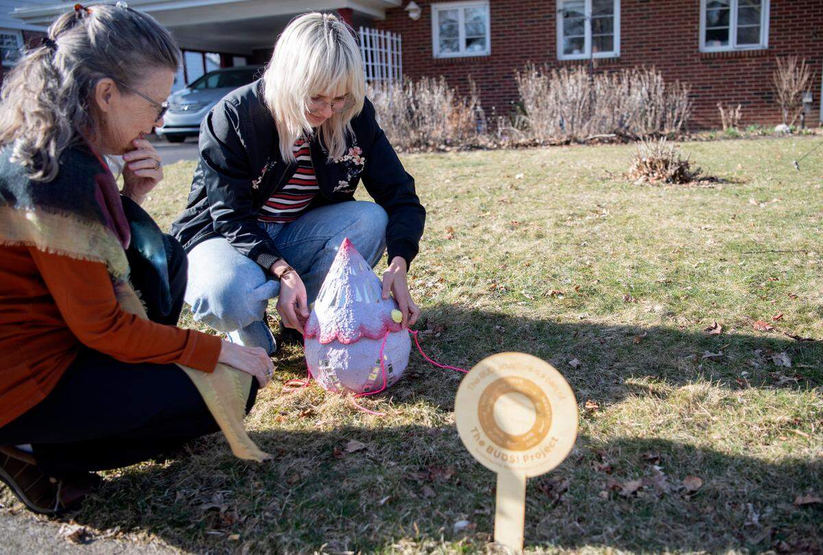 Alex Russell shows how to open and leave a gift inside of her art installation, Buds!, on Monday. Russell is a graduate student in the Penn State School of Visuals Arts.