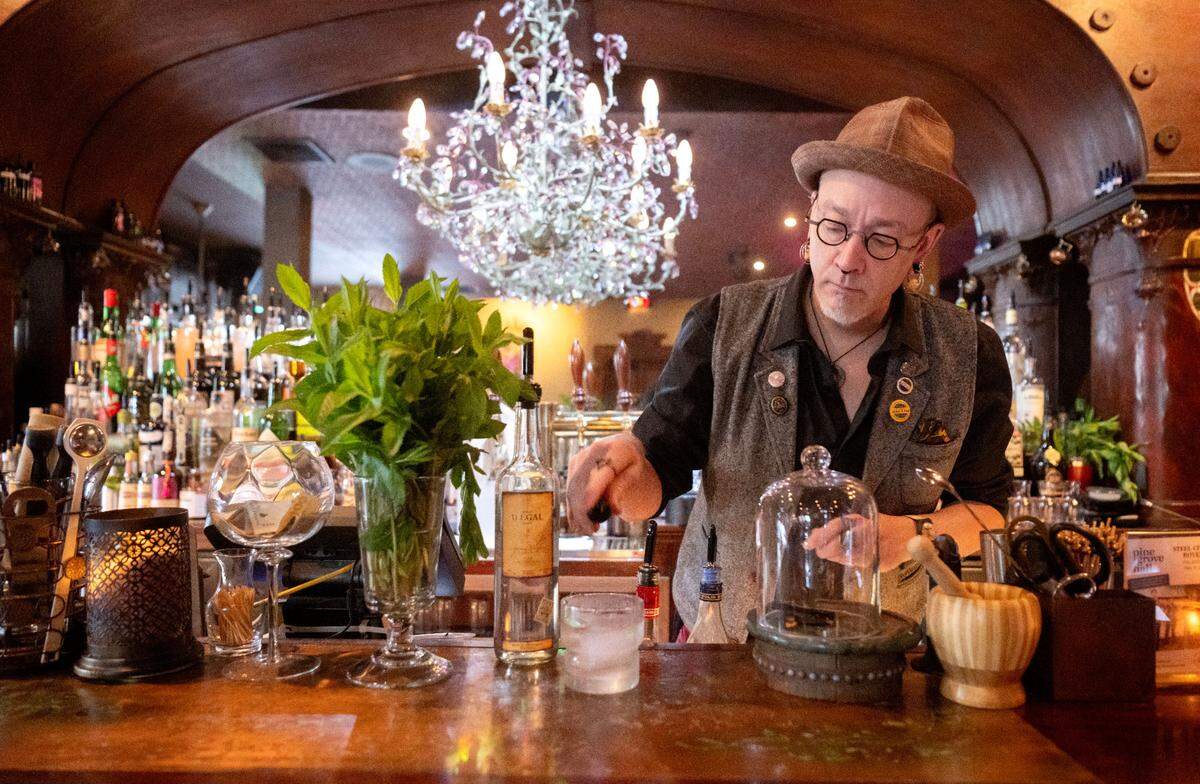 Sc’Eric Horner taps the Peychaud’s bitters into a White Lodge cocktail at Pine Grove Hall on Thursday, May 23, 2024.