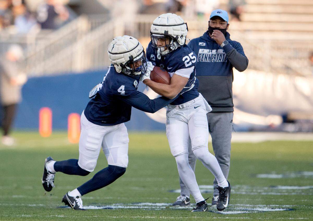 Penn State cornerbacks Kalen King and Daequan Hardy run a drill during football practice as cornberbacks coach Terry Smith watches on Friday, April 23, 2021 at Beaver Stadium.