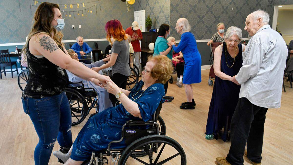 Staff members dance with residents at Wynwood House in Boalsburg Friday during a “senior prom.”