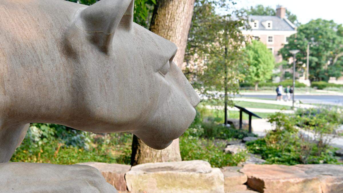 Masked students walk along Curtin Road past the Nittany Lion Shrine on the Penn State University Park campus on Tuesday, Sept. 15, 2020.