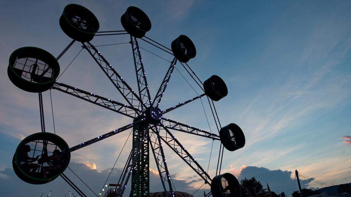 The sun sets over the Bartlebaugh Amusements rides at the Centre County Grange Fair on Thursday, Aug. 26, 2021.