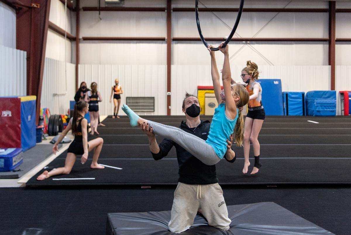 Dmitry Myers works with Brielle Long, 12, on the lyra as the gymnastic team practices at the Phoenix Academy of Performing Arts of Pennsylvania on Tuesday, Dec. 7, 2021.