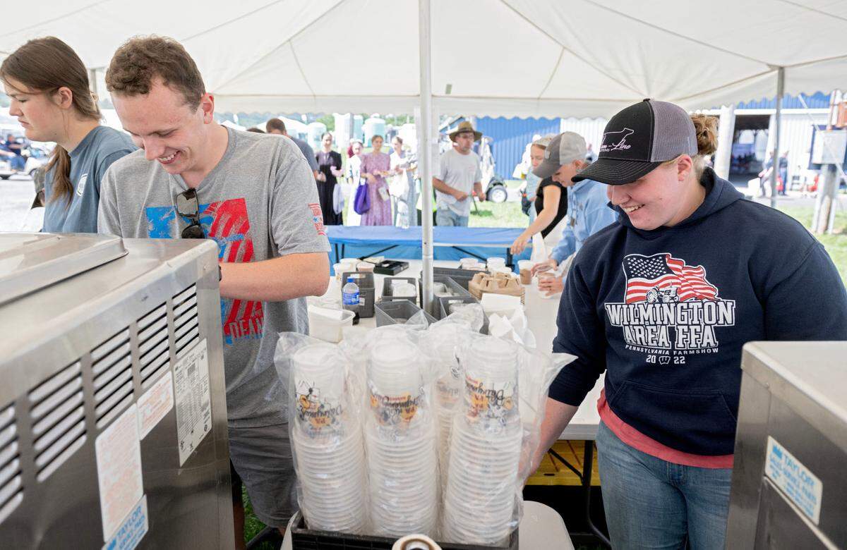Volunteers from the Pennsylvania Jr. Guernsey Breeders Marc Galante and Renee Elay serve milkshakes at the Penn State Ag Progress Days on Tuesday, August. 13, 2024.