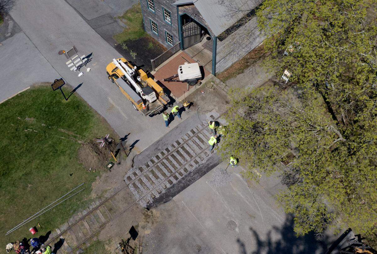Members of the Bellefonte Historical Railroad Society and College Township work to replace the train tracks that cross Mount Nittany Road by the granary in Lemont on Wednesday, April 8, 2026.  