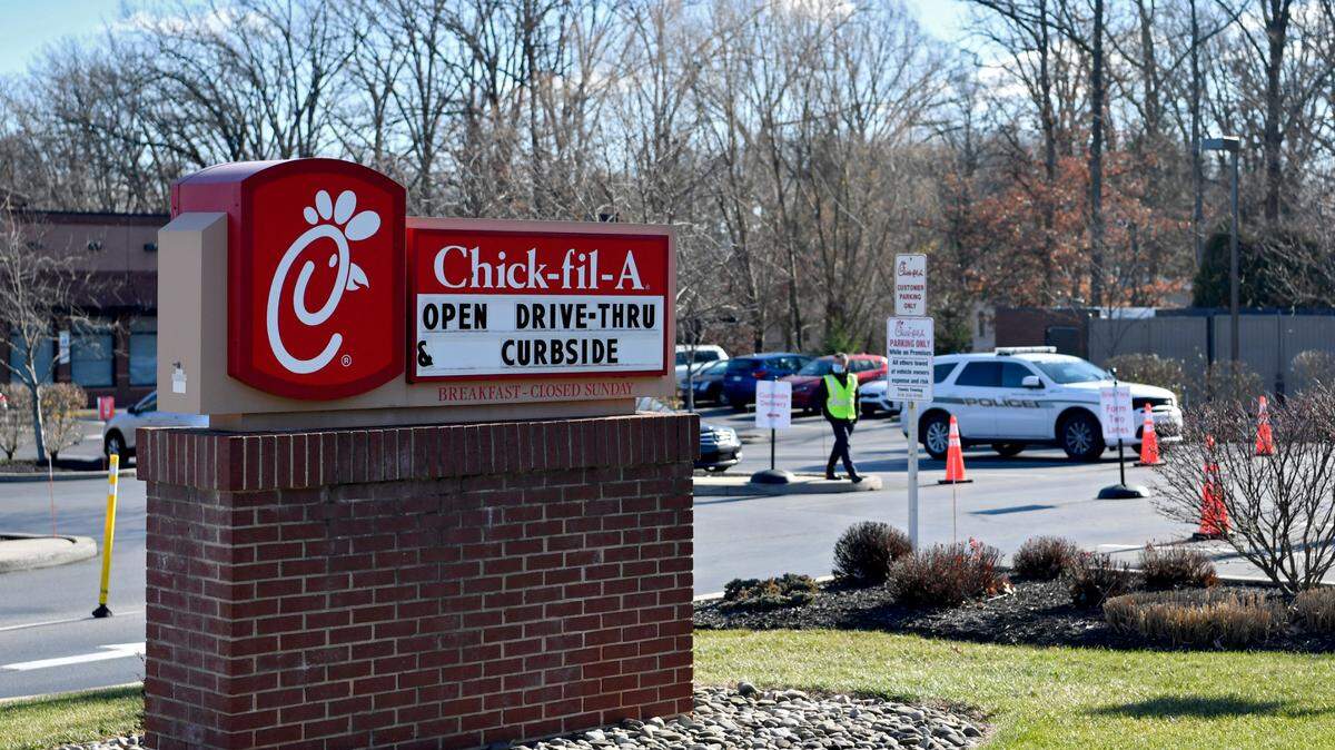 The owner of Chick-fil-A stands in the parking lot to talk with patrons as the Patton Township police monitor and ticket those who made a left turn from North Atherton Street into the establishment on Tuesday, Dec. 8, 2020.